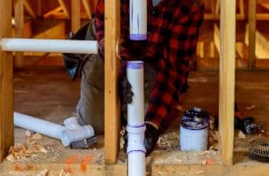 Plumber installing PVC pipe